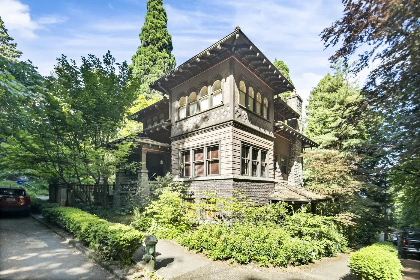 Restored historic craftsman home surrounded by evergreens