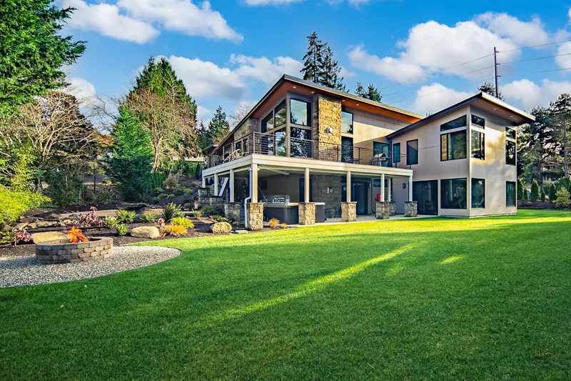 Rear of the home with a covered patio and a wide lawn