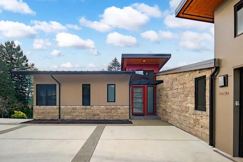 Front entry with a red door and a stone accent wall
