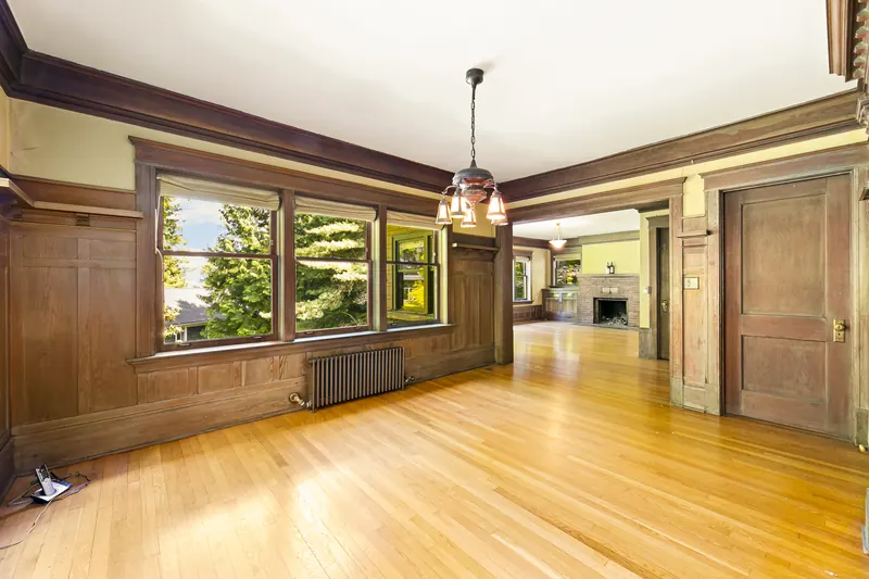 Dining room with original dark wood paneling and a pendant light