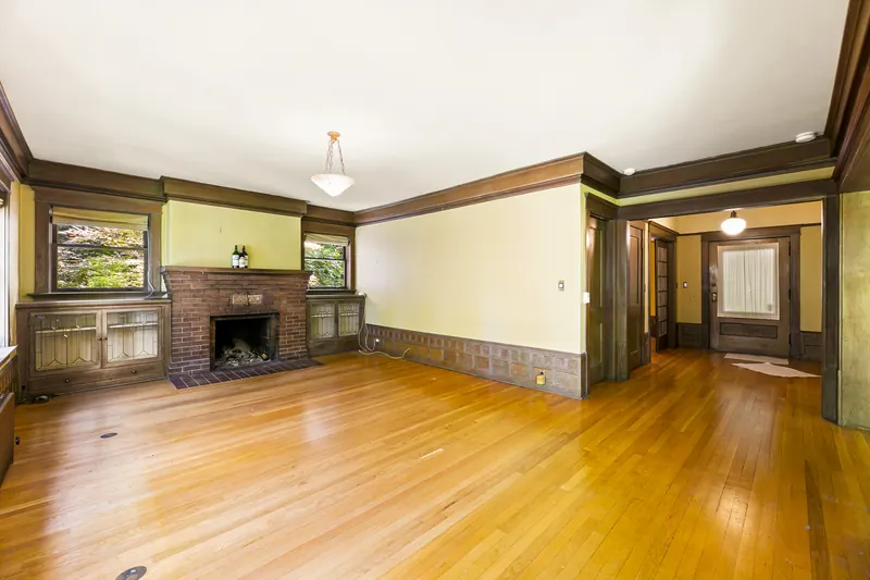 Living room with a brick fireplace and original built-ins