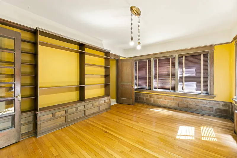 Den with built-in bookshelves and wood paneling