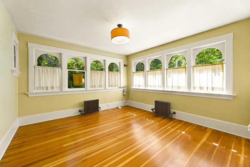 Sunroom with arched windows and radiators