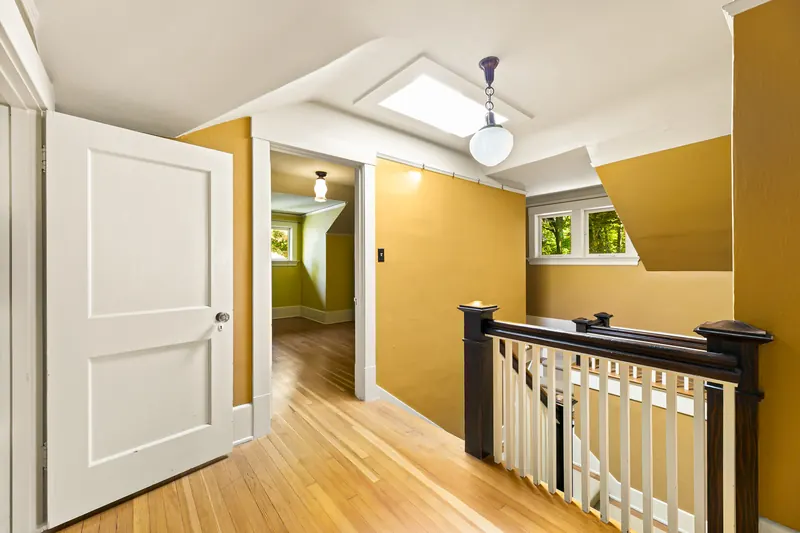 Upstairs landing with a wood stair railing