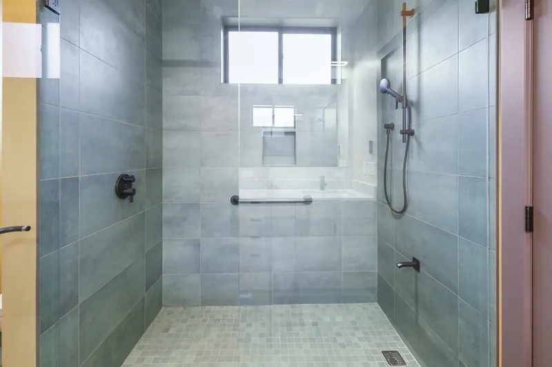 Walk-in glass shower with gray tile