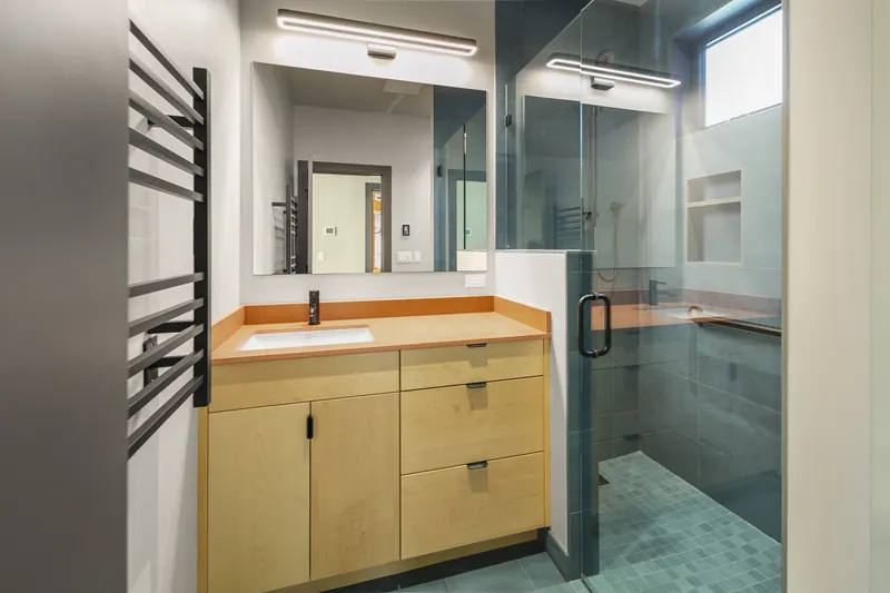 Wood bathroom vanity next to the glass shower