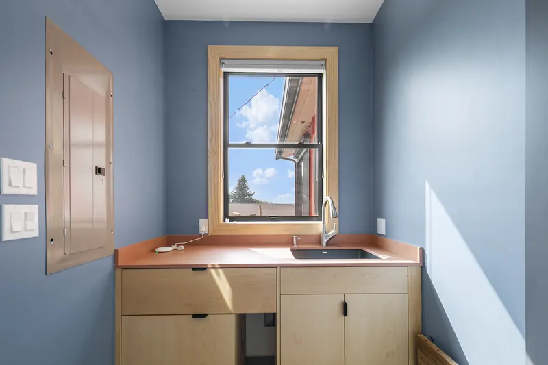 Utility room with a wood cabinet and a sink