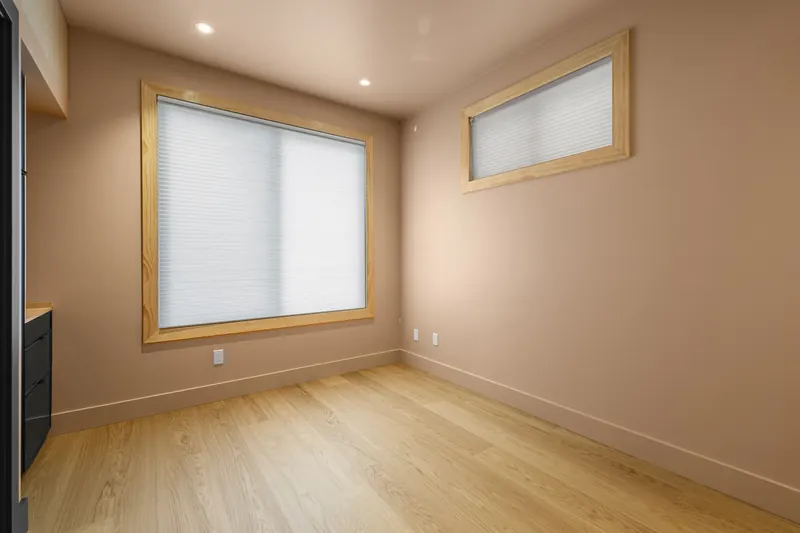 Room with warm walls, oak floors and trimmed windows